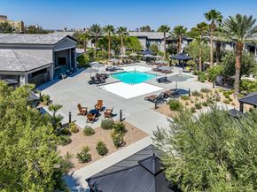 Las Vegas apartment for rent - A pool surrounded by palm trees and patio furniture.