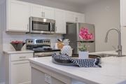 Columbus apartment for rent - A kitchen with white cabinets and a checkered cloth on the counter.