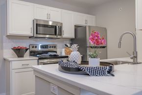 Columbus apartment for rent - A kitchen with white cabinets and a checkered cloth on the counter.