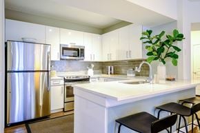 Magnolia apartment for rent - A modern kitchen with a stainless steel refrigerator and white countertops.