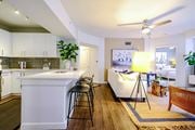 Jupiter apartment for rent - A modern kitchen with white cabinets and a white island with a bar stool.