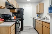 Grove City apartment for rent - A kitchen with wooden cabinets and a black refrigerator.