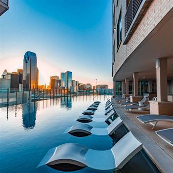 Infinity edge pool with outdoor soft seating and lounges with fantastic views of downtown and uptown