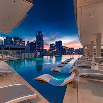 Infinity edge pool with outdoor soft seating and lounges with fantastic views of downtown and uptown