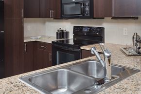 Houston apartment for rent - A kitchen with a black stove and microwave.