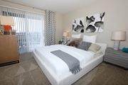 San Jose apartment for rent - A bedroom with a large bed, a nightstand, and a window with blinds.