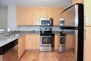 San Jose apartment for rent - A kitchen with wooden cabinets and stainless steel appliances.