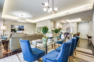 Houston apartment for rent - A modern living room with blue chairs and a glass table.