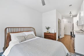 Washington Dc apartment for rent - A bedroom with a bed, nightstand, and a plant on the nightstand.