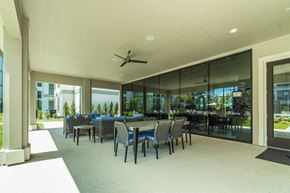 Rowlett apartment for rent - A spacious room with tables and chairs and a ceiling fan.