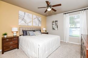 Humble apartment for rent - A bedroom with a bed, nightstand, and a ceiling fan.