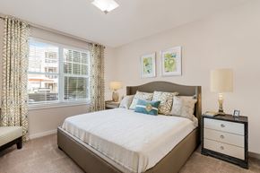 Fuquay-Varina apartment for rent - A bedroom with a large bed, a nightstand, and a window with curtains.