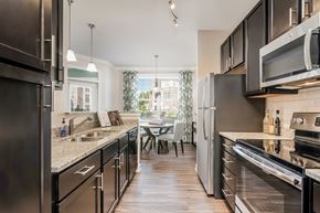 Fuquay-Varina apartment for rent - A modern kitchen with dark wood floors and stainless steel appliances.
