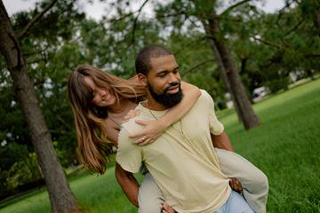 San Francisco apartment for rent - A man is carrying a woman on his back in a park.