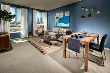 Los Angeles apartment for rent - A living room with a grey carpet and a wooden dining table.