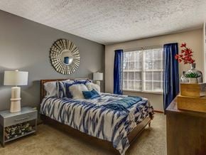 Columbus apartment for rent - A bedroom with a bed, nightstand, and a mirror on the wall.