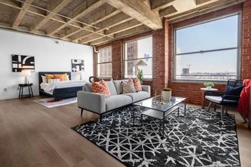 Los Angeles apartment for rent - A living room with a grey couch and a glass coffee table.