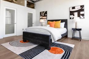Los Angeles apartment for rent - A bedroom with a large bed and a rug with a circular design.