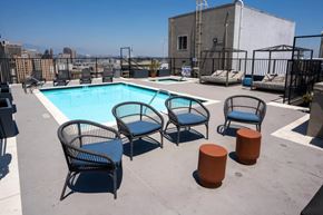 Los Angeles apartment for rent - A pool with four chairs and two stools on a rooftop.