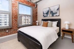 Los Angeles apartment for rent - A bedroom with a large bed and a window overlooking a cityscape.