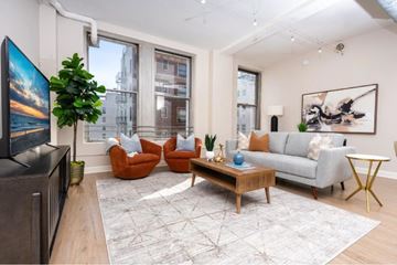 Los Angeles apartment for rent - A living room with a grey couch, a wooden coffee table, and a large painting on the wall.