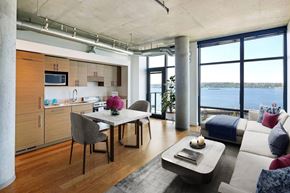 Seattle apartment for rent - A modern kitchen with a dining table and a couch with a view of the water.