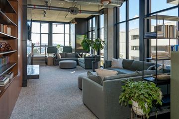 Seattle apartment for rent - A modern living room with a grey sofa and a large window.