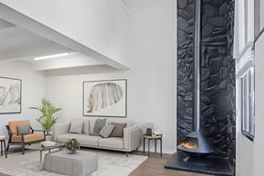 Aurora apartment for rent - A modern living room with a grey sofa, a coffee table, a fireplace, and a potted plant.