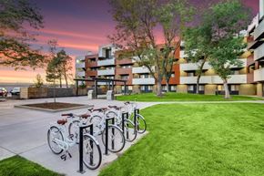 Aurora apartment for rent - A row of bicycles are parked on a sidewalk in front of a building.