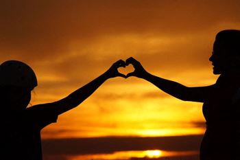 Silhouette-of-man-touching-woman-against-sunset-sky
