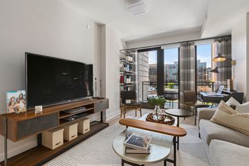 Washington apartment for rent - A living room with a television and a view of the city.