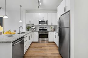 Stamford apartment for rent - a modern kitchen with stainless steel appliances and white cabinets