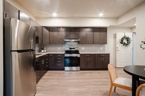 Fort Collins apartment for rent - A modern kitchen with a stainless steel refrigerator and wooden flooring.
