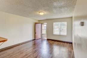 Windsor townhouse for rent - the living room and dining room of an empty house with wood floors and a door