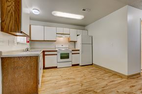 Fort Collins apartment for rent - an empty kitchen with white appliances and wood flooring