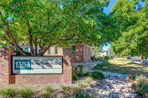 Fort Collins apartment for rent - a sign in front of a brick building with a tree