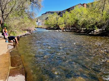 A river flows through a natural landscape with people enjoying the water.
