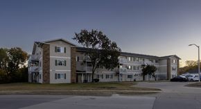 Des Moines apartment for rent - an apartment building on a street corner at dusk