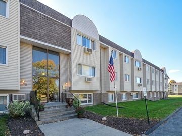 Urbandale apartment for rent - A building with a grey facade and a flag on a pole.