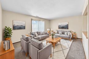 Des Moines apartment for rent - A living room with a grey couch, a coffee table, and a rug.