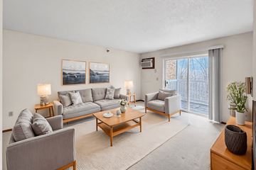 Des Moines apartment for rent - A living room with a grey couch, a coffee table, and a painting on the wall.