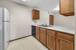 Des Moines apartment for rent - A kitchen with wooden cabinets and a white fridge.