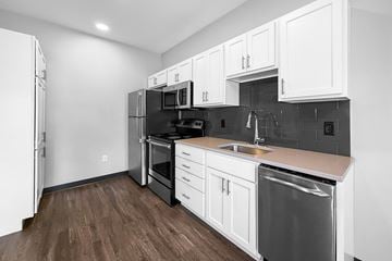 Des Moines apartment for rent - A kitchen with white cabinets and a black refrigerator.