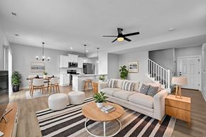 Van Meter townhouse for rent - A modern living room with a white sofa, wooden coffee table, and a striped rug.