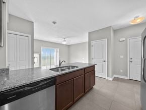 Urbandale condo for rent - A kitchen with a black dishwasher and a granite countertop.