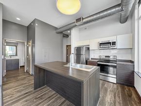Des Moines apartment for rent - A modern kitchen with a wooden island and stainless steel appliances.