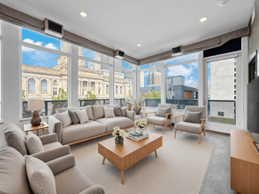 Des Moines apartment for rent - A living room with a large window overlooking a cityscape.
