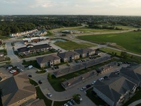 Urbandale condo for rent - A large aerial view of a residential area with houses and a parking lot.