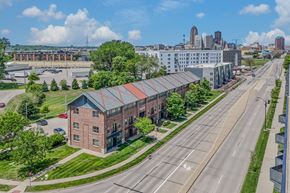 Des Moines apartment for rent - A city street with a building on the left and a city skyline in the background.