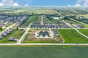 Van Meter townhouse for rent - A bird's eye view of a residential area with a large green field in the foreground.